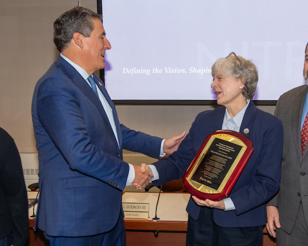 Commissioner Stephen Shaw congratulates Commissioner Bette Jane Kowalski on her retirement.