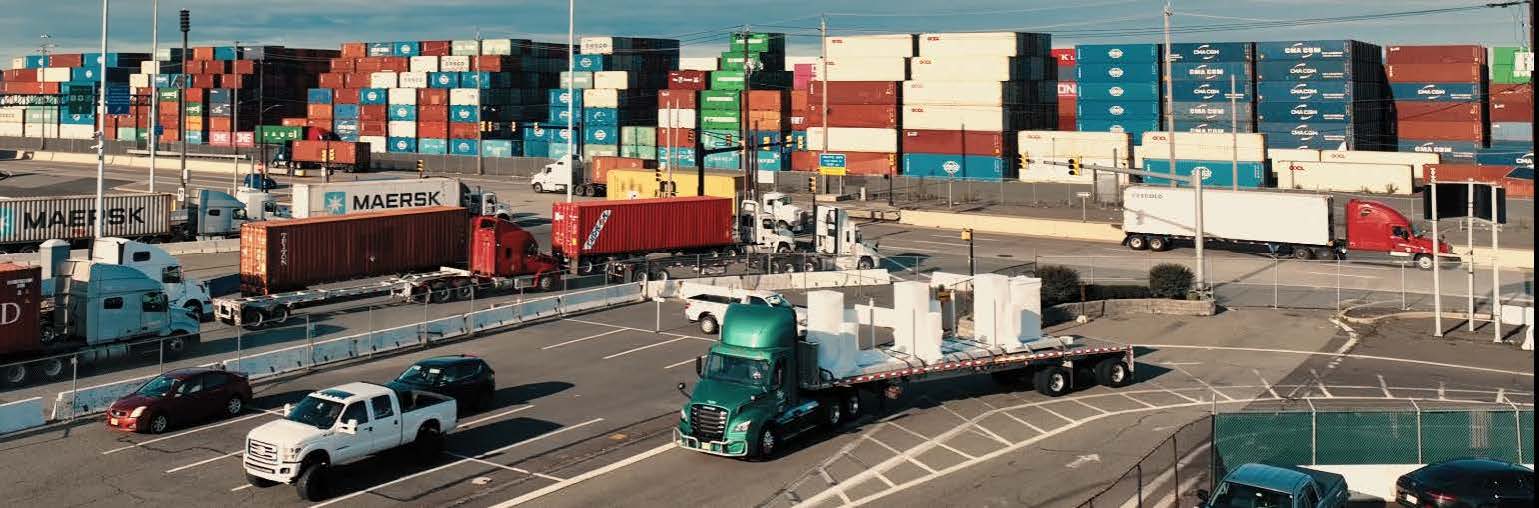 IMF trucks parked at Port Newark with containers in background