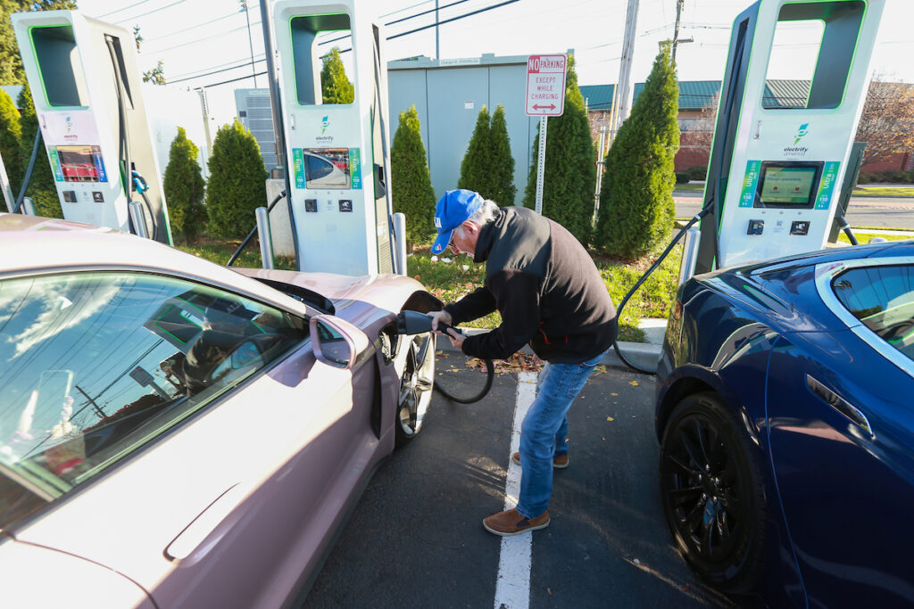 Man plugs in car at electric vehicle charging station in Bridgewater, Somerset County.