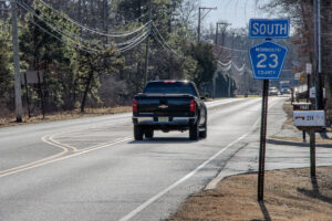 Pickup truck passes Monmouth County Route 23 sign on Jackon Mills Road.