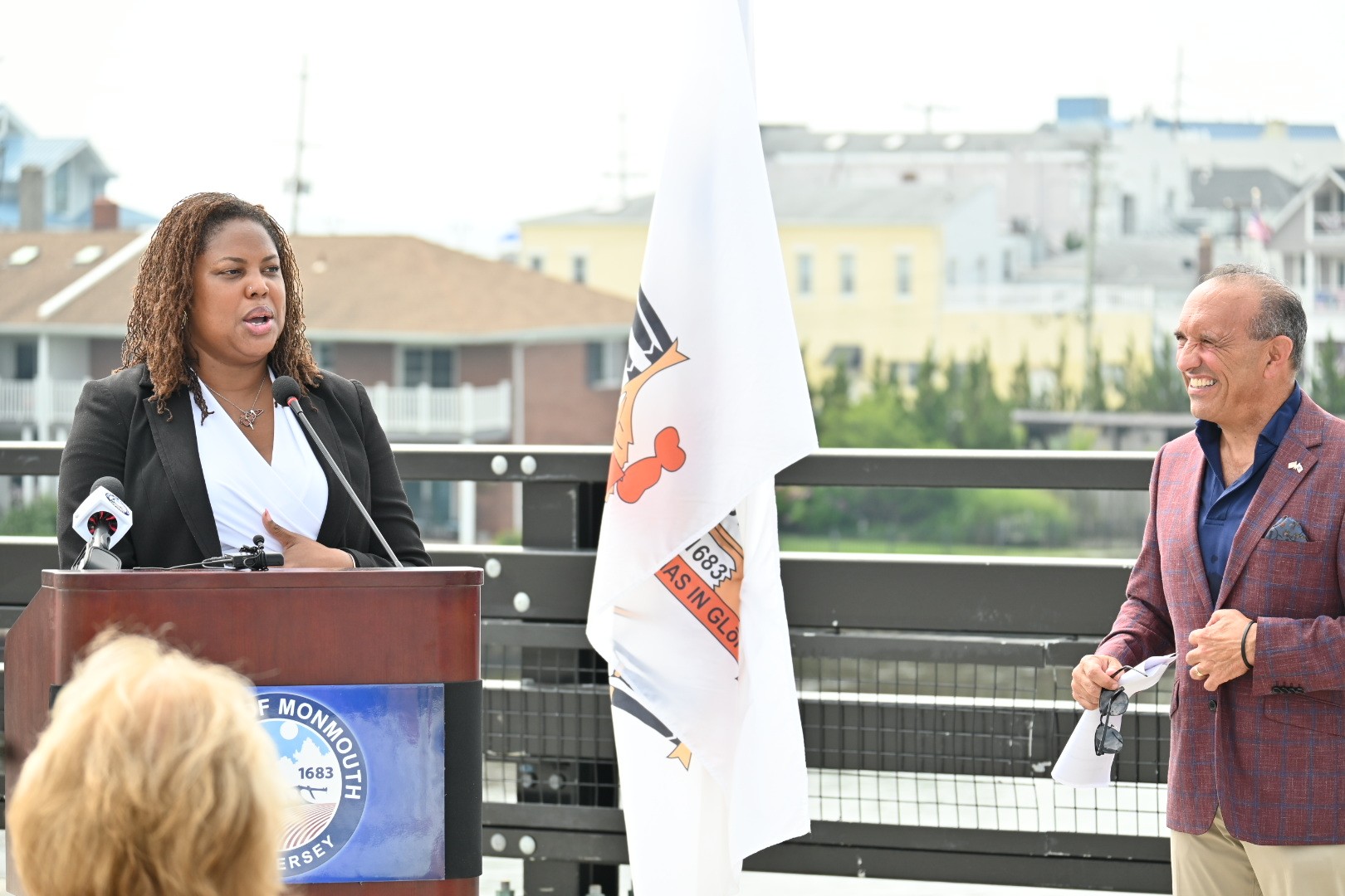 Sascha Frimpong speaks at podium as Tom Arnone looks on