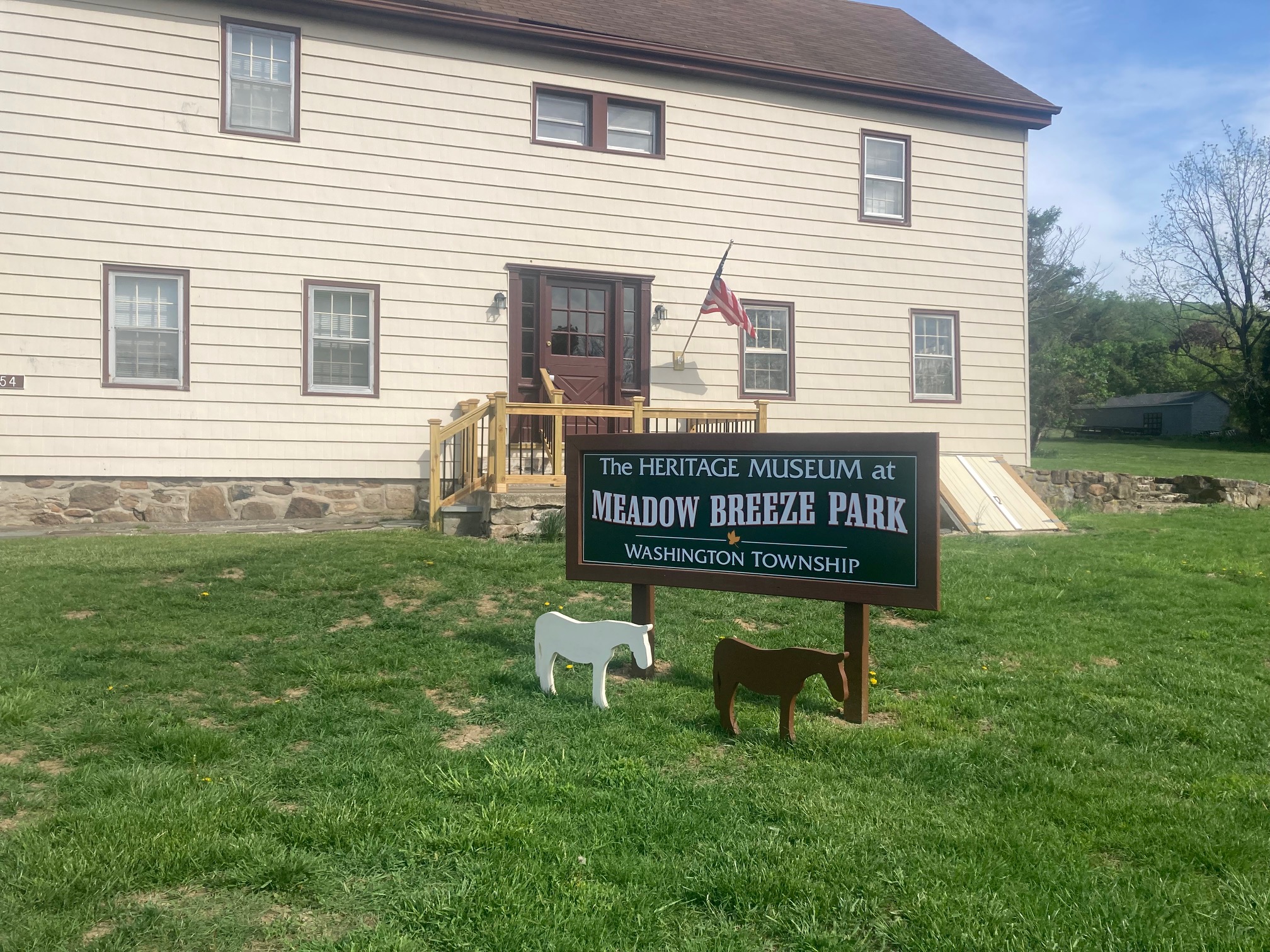 Two wooden mule silhouettes in front of Heritage Museum at Meadow Breeze Park sign