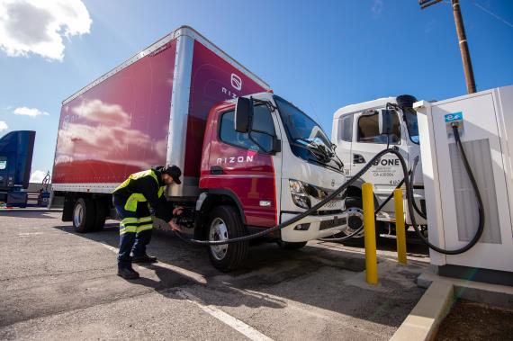 Man charges red electric truck