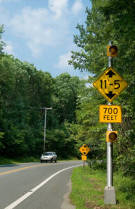 Roadside sign warns of 11-foot, 5-inch bridge clearance in 700 feet