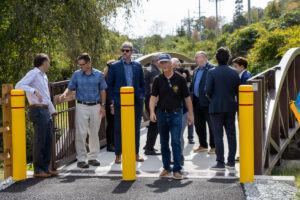 People gather on pedestrian bridge along Highlands Rail Trail ahead of ribbon cutting ceremony.