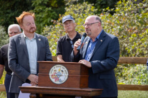 Wanaque Mayor Dan Mahler speaks at podium during ribbon cutting ceremony for Highlands Rail Trail.