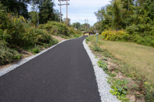 Stretch of paved path along Highlands Rail Trail with bridge in background