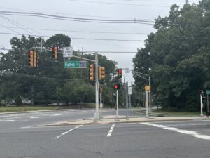 Ryders Lane sign hangs from vertical traffic signal.
