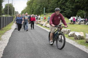 Man on bicycle ahead of group of walkers on Pompton Valley Rail Trail
