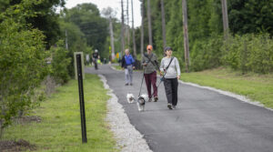 Couple walks with leashed dog along Pompton Valley Rail Trail