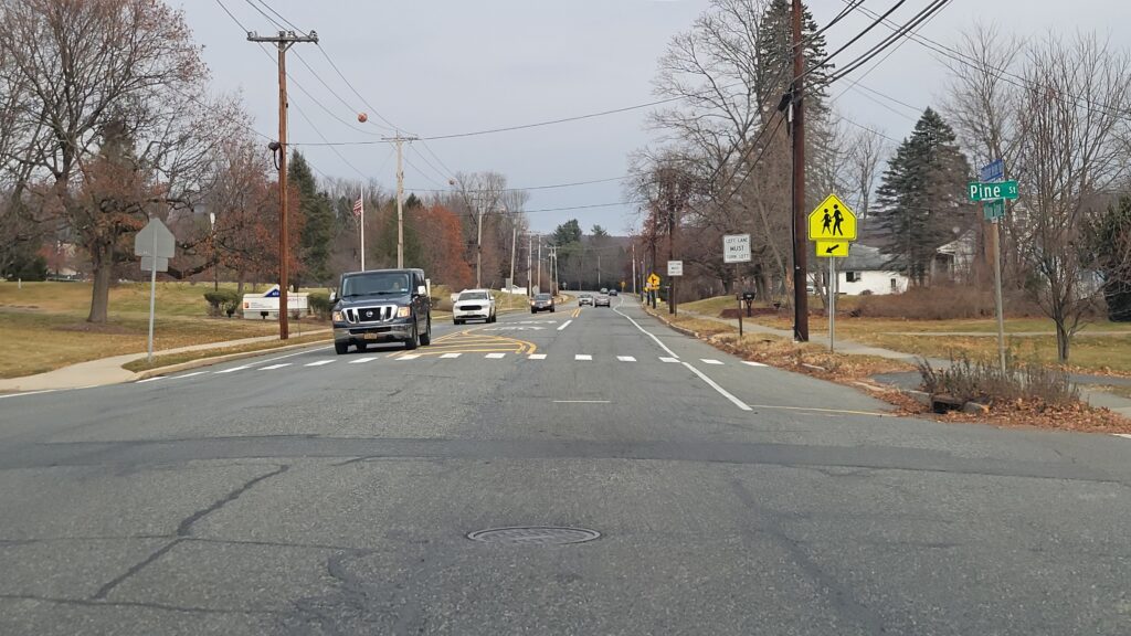 Pickup truck passes through intersection of Pine Street in Hackettstown, Warren County, trailed by two cars.