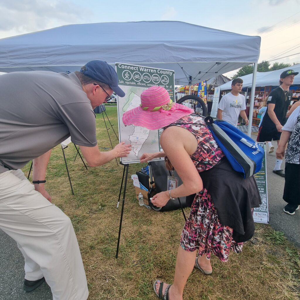 A woman places stickers on a map as part of public outreach for the Connect Warren County subregional study.